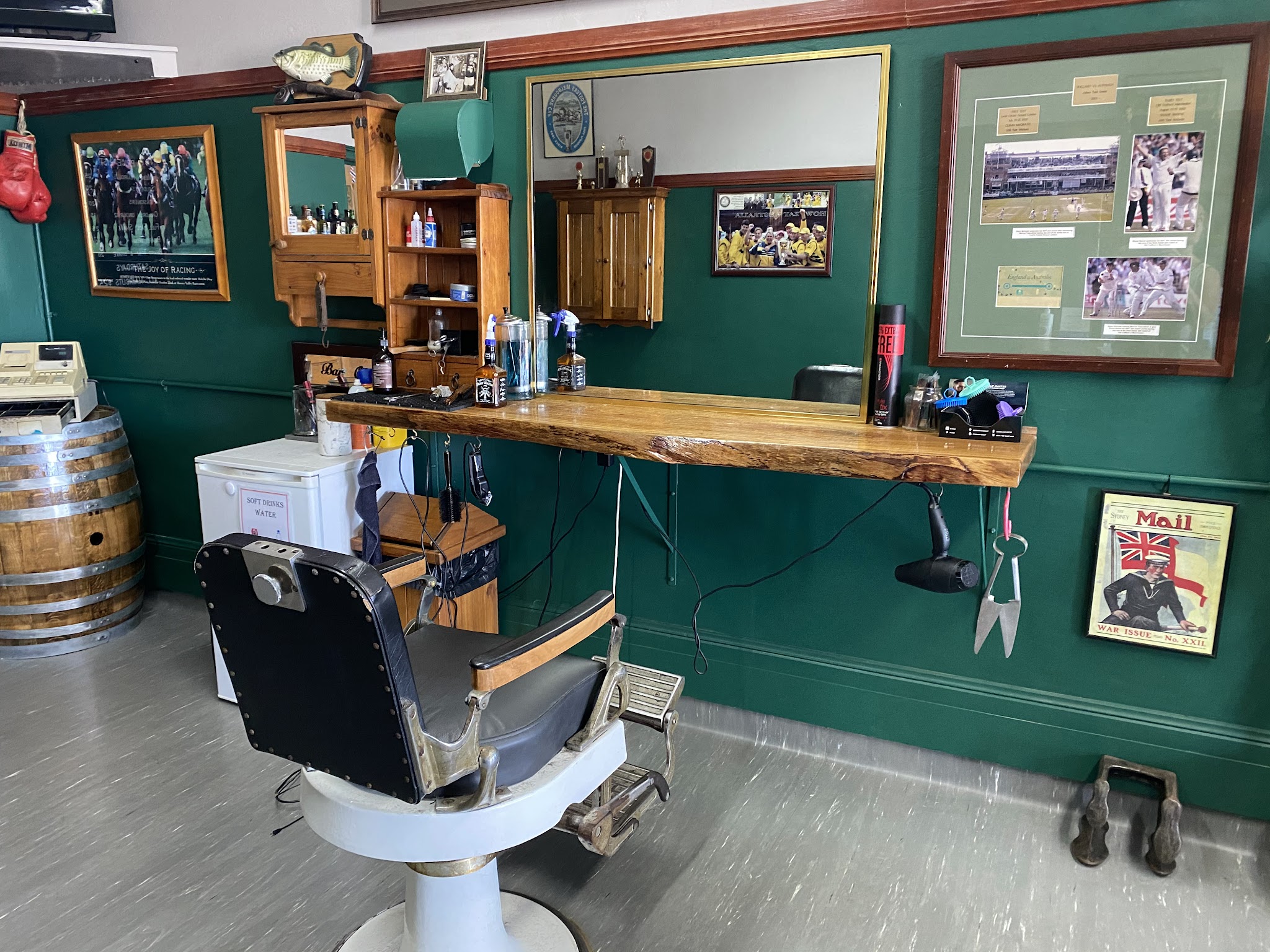 Barber station with mirror, timber shelf and framed racing memorabilia