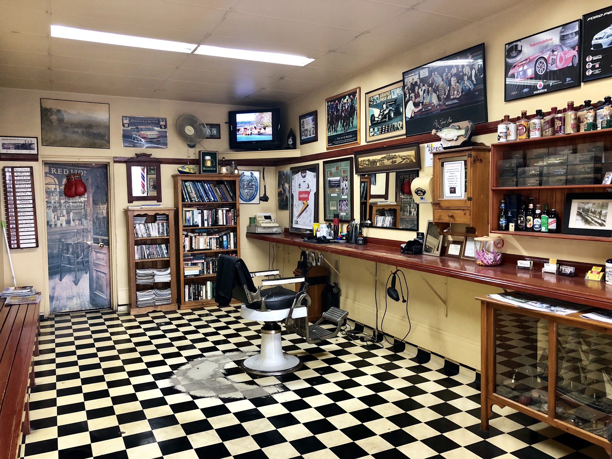 Interior of Nico's Barber Shop looking towards the Red Lion door, with bookshelves and the barber chair